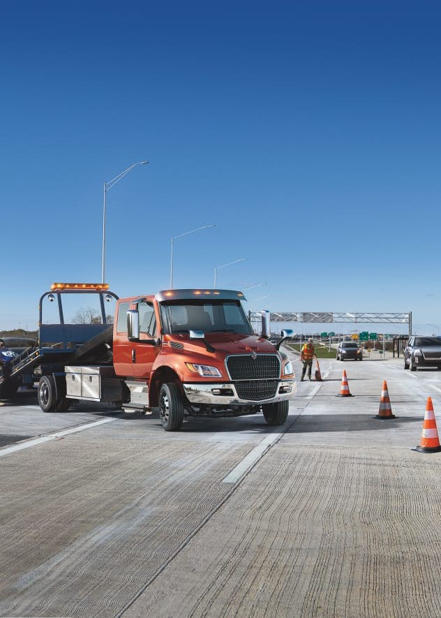A tow truck with a tow truck on the side of the road