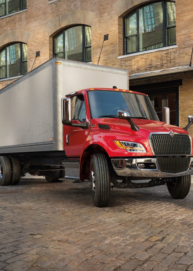 A red truck parked in front of a brick building