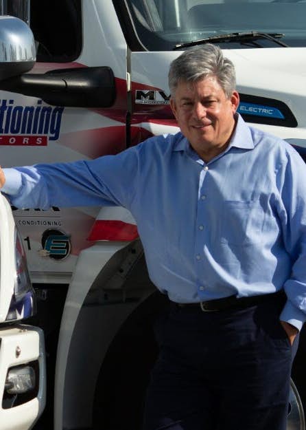 A person leaning on a truck