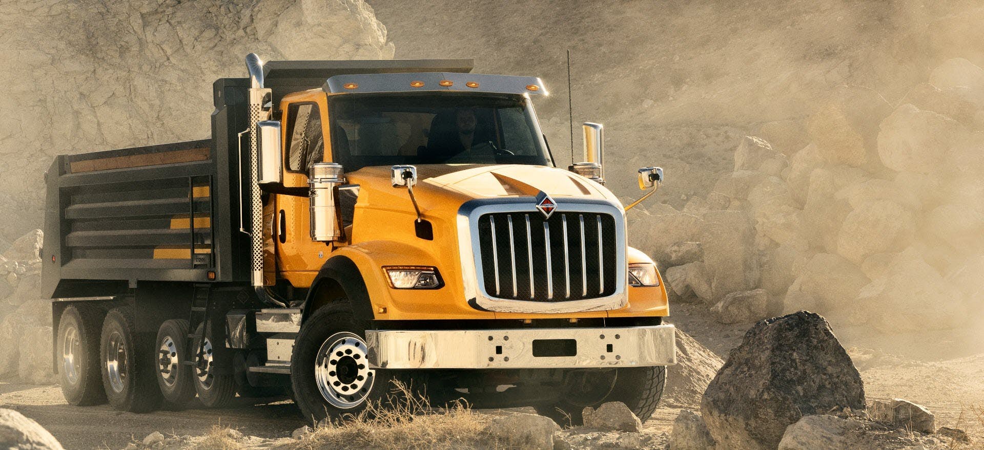 A yellow truck on a dirt road