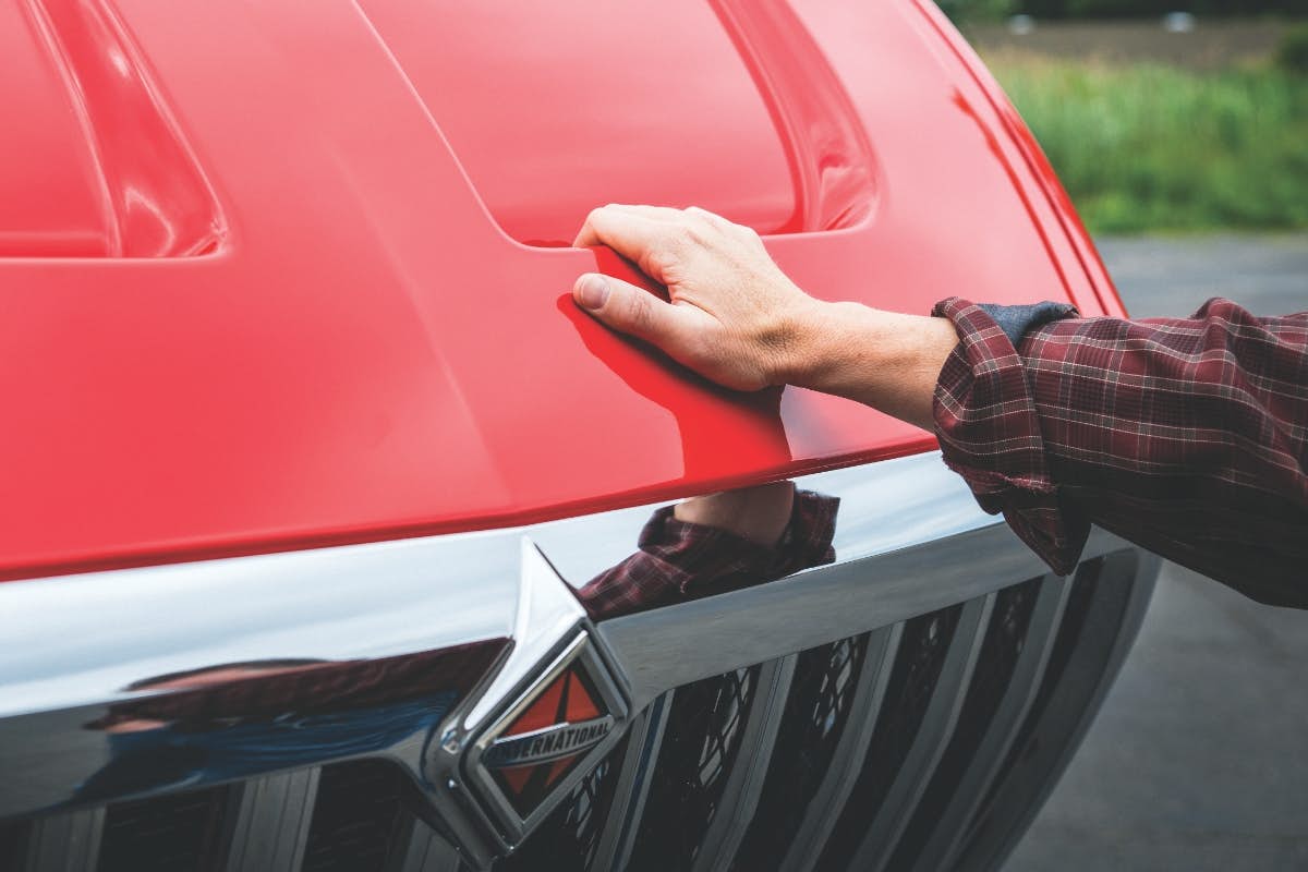 A hand on a red car