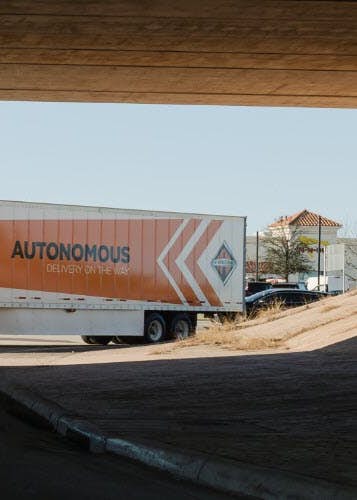 A truck driving under a bridge