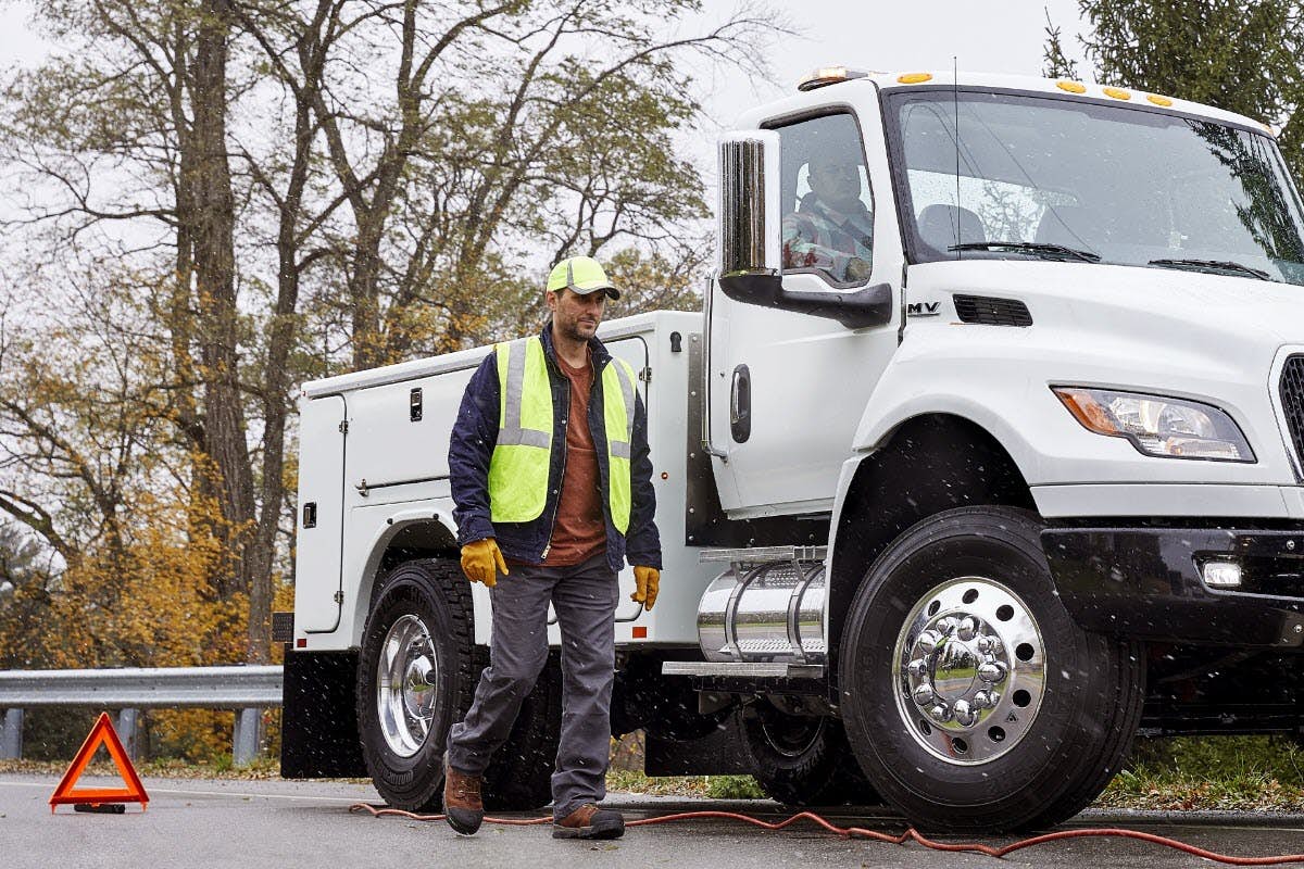A person standing next to a large truck