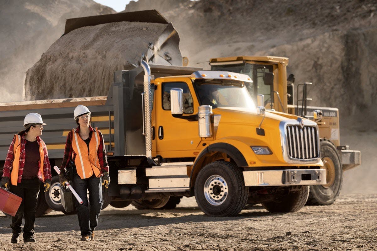 A person walking next to a construction truck