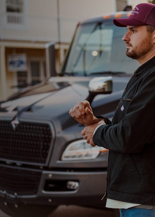 Truck driver standing in front of truck