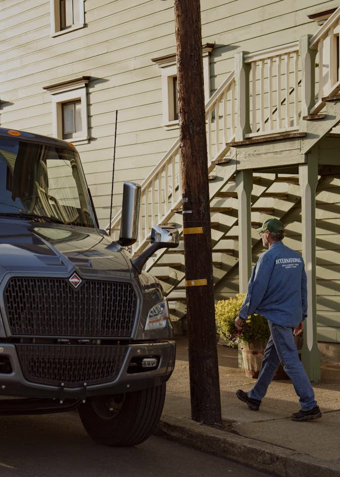 A person walking on the sidewalk next to a truck