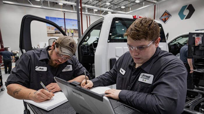 A couple of men working on a laptop