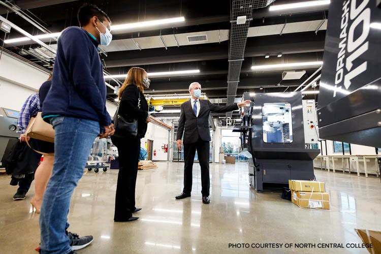 A person wearing a mask and standing in a factory