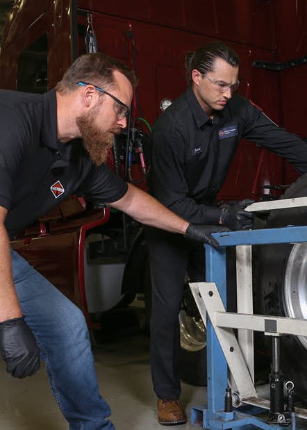 A couple of men working on a tire