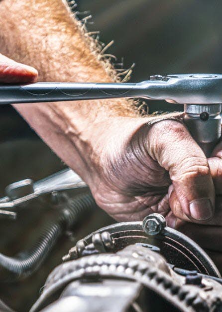 A close-up of a person's hands holding a wrench
