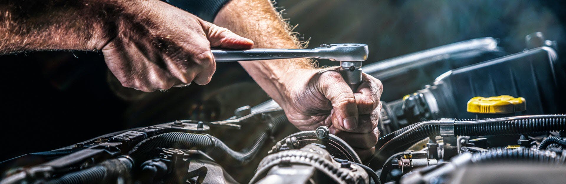 A close-up of a person's hands holding a wrench