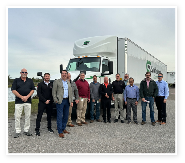 A group of people standing in front of a truck
